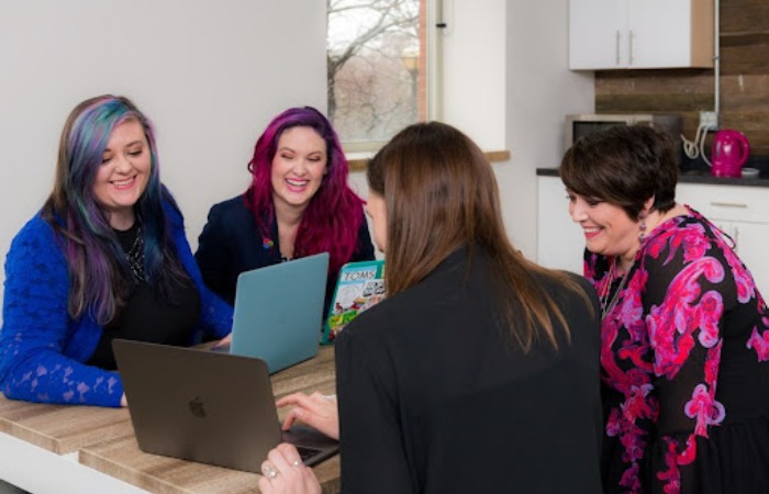 A group of professionals in an office conference room gathered around a table, discussing leveraging data and insights for hyper-personalized sales strategies